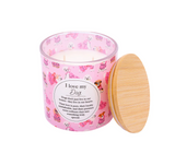 Pink candle with dog illustrations and a wooden lid on a white background